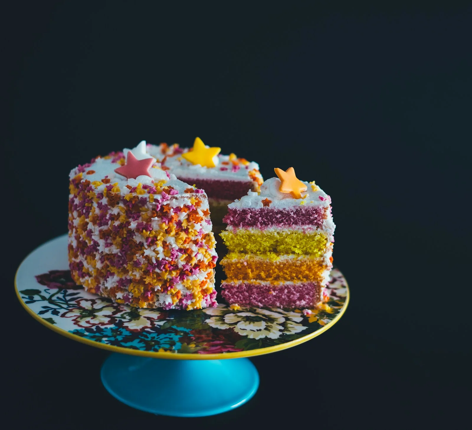 Torta de cumpleaños personalizada de colores con una porción cortada